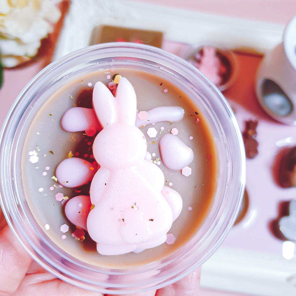 Chocolate Wax Melts featuring a pink bunny shape and shiny sprinkles in a round container.